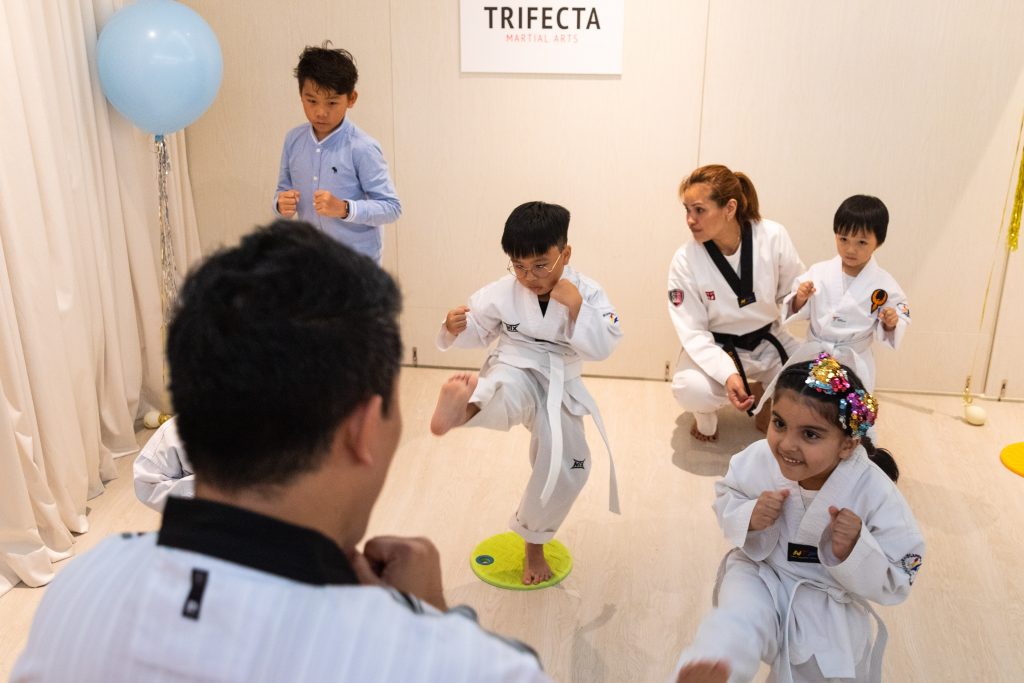 The little ones practicing their kicks with the help of the teachers at Trifecta Martial Arts.