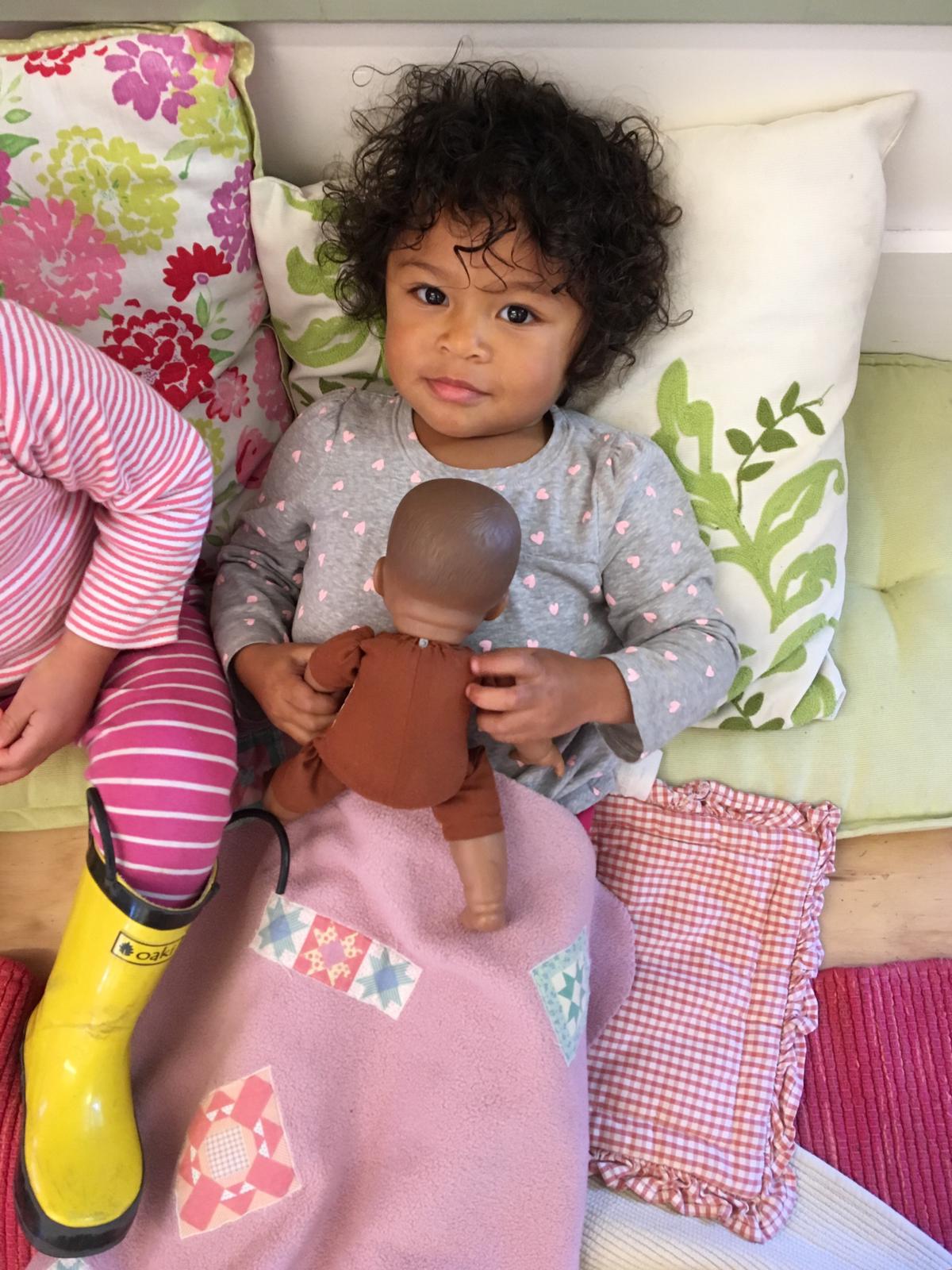 Katherine playing with a doll in her Montessori preschool.